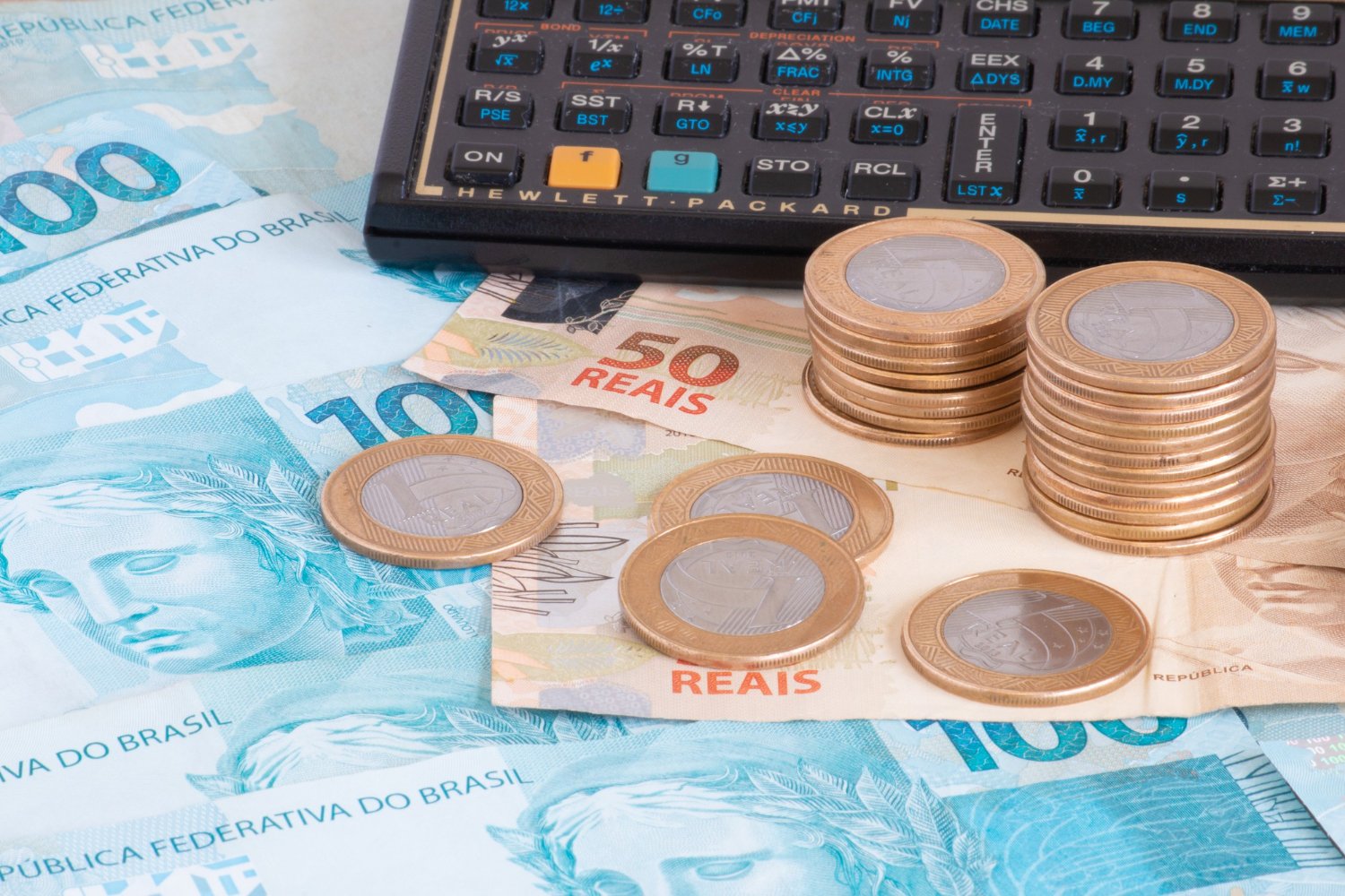finance-concept-one-hundred-reais-bills-coins-with-calculator-pen-brazilian-money1
