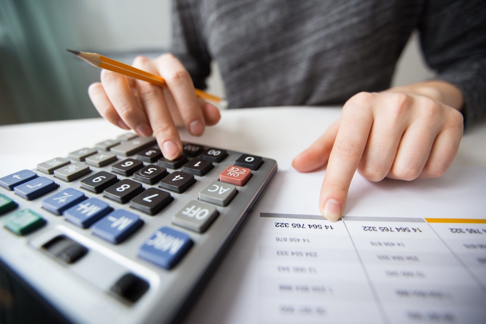 closeup-accountant-hands-counting-calculator-min-scaled